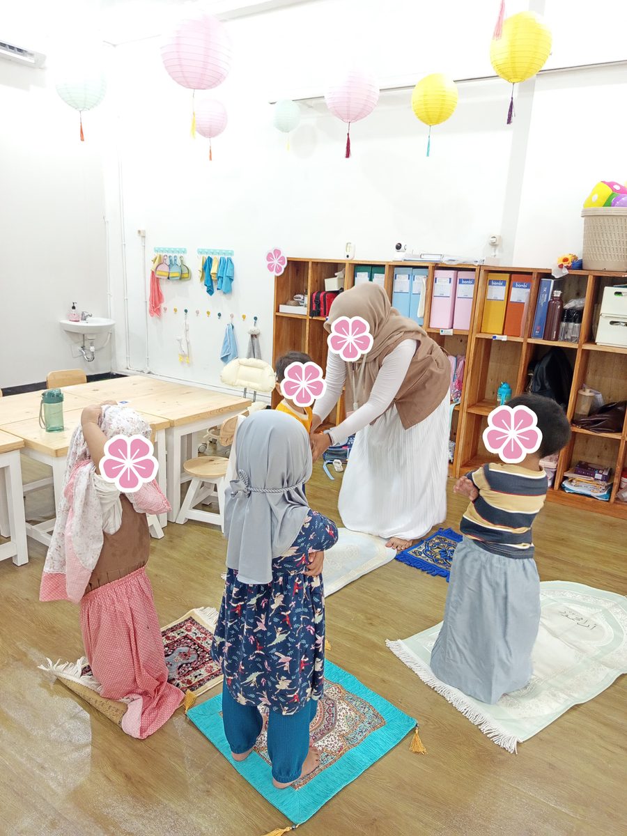 Anak-anak berlatih shalat berjamaah di atas sajadah bersama guru