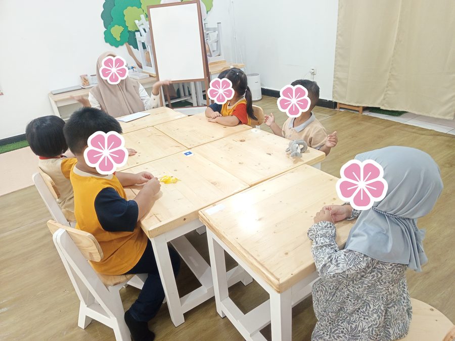 Anak-anak belajar bersama mengelilingi meja kelas
