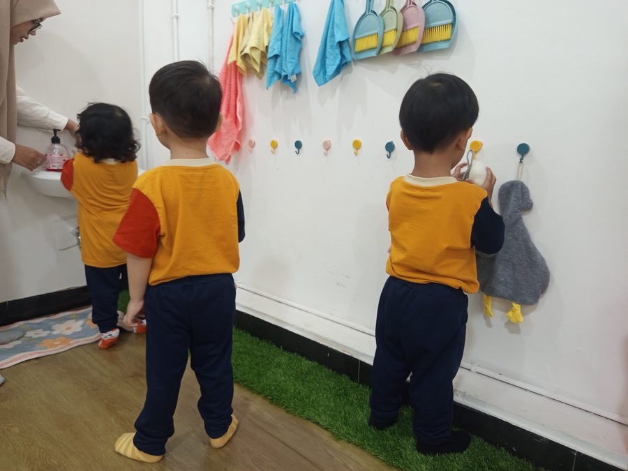 Anak-anak menggantung handuk sendiri sebagai rutinitas kemandirian