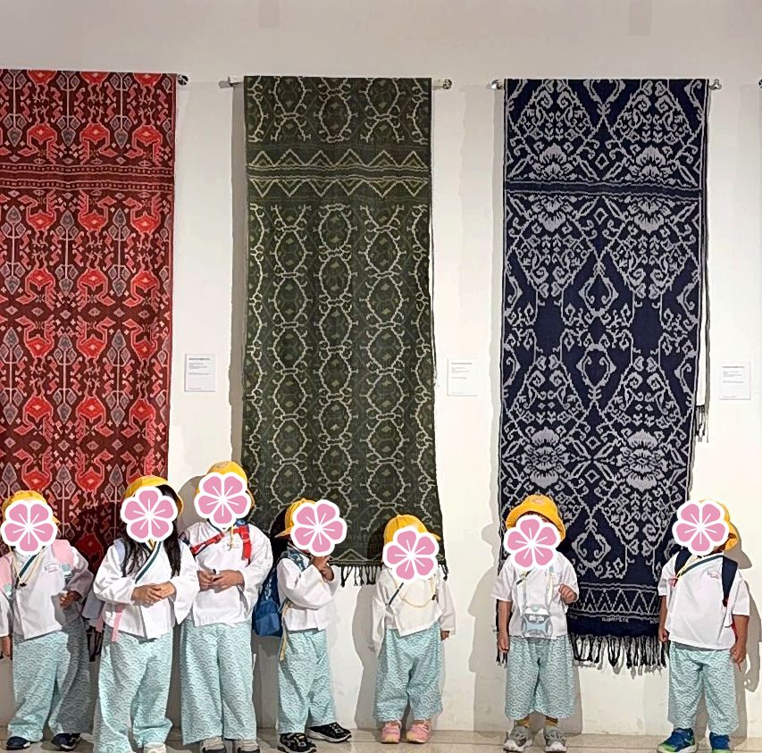 Anak-anak bertopi kuning mengunjungi museum tenun