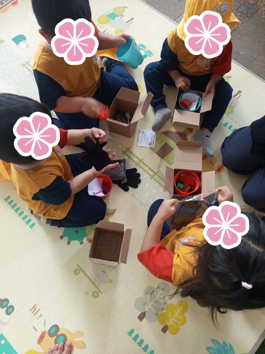 Anak-anak mengeksplorasi kotak sensori bersama secara berkelompok