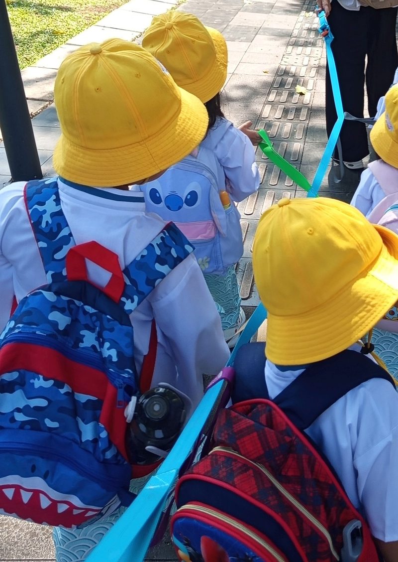 Anak-anak berjalan rapi mengenakan topi kuning saat field trip